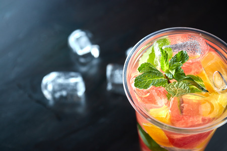 detox lemonade with grapefruit and orange slices with fresh citrus and ice on a black wooden background. view from above. refreshing drink.の写真素材