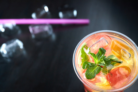 detox lemonade with grapefruit and orange slices with fresh citrus and ice on a black wooden background. view from above. refreshing drink.の写真素材