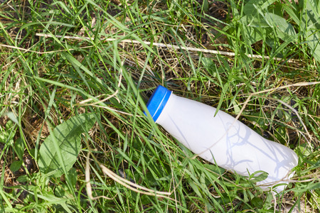 plastic bottle in green grass in the forest. environmental pollution by plastic. protection of ecology.の写真素材