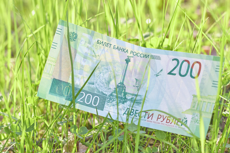 Banknote Two hundred Russian rubles. Paper Russian money on the background of green grassの写真素材