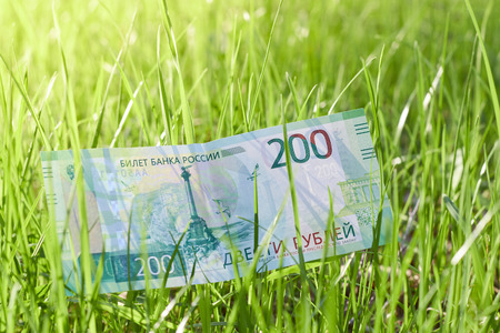 Banknote Two hundred Russian rubles. Paper Russian money on the background of green grassの写真素材