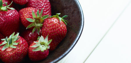 Fresh strawberries on wooden bowl. Sackcloth background. Copy writing space.の写真素材