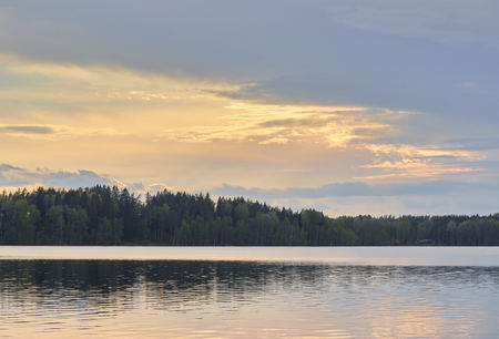 Beautiful mountain lake before giant mountains under blue sky with white clouds. Forest edge on slope. Amazing water in sunny day. Wonderful mountainscape. Colorful scenic landscape. Highland scenery.の写真素材