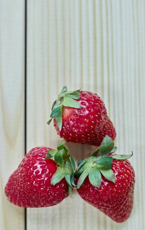 Red juicy strawberries on a light wooden table. with copy space. close-up view.の写真素材