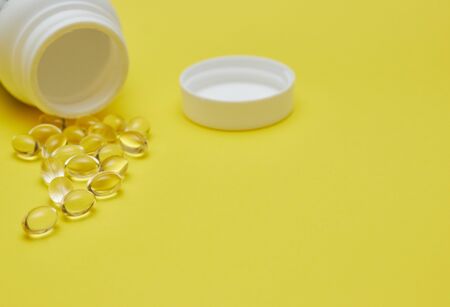 Assorted pharmaceutical medicine pills, tablets and capsules and bottle on blue background. Copy space for textの写真素材