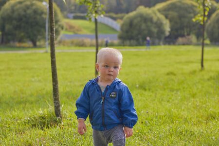 St. Petersburg, Russia, August 5, 2019.Cute little blond boy is walking in the clear summer weather in the park. The concept of childhood children and family relationships. child protection.のeditorial素材