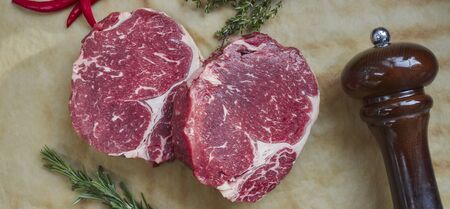 red raw filet. two fresh steaks with a sprig of thyme and rosemary. view from above. grilled meat.の写真素材