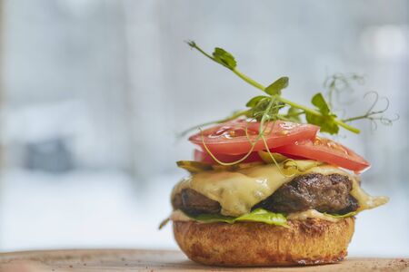 open burger with beef patty, red tomato and cream cheese close-upの写真素材