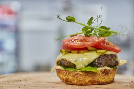 open burger with beef patty, red tomato and cream cheese close-upの写真素材