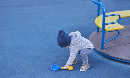 little boy alone plays in the playground.の写真素材