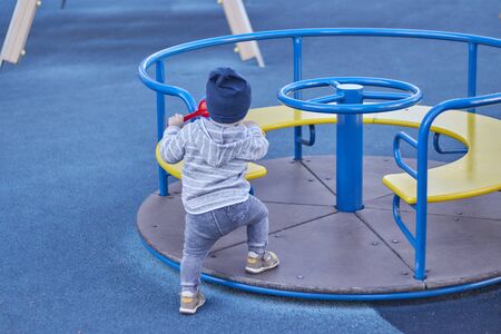 little boy alone plays in the playground.の写真素材