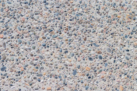 Background of multi-colored pebbles on the seashore. Sea stones of various sizes cover the sea coast. Pebble texture. Concept of natural background from stones. The surface of the rocky beach.の写真素材
