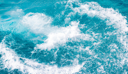 Splashes of blue, sea water with foam bubbles. A splash of nature on a summer day. blue sea background with splashing water. sea vacation concept.の写真素材