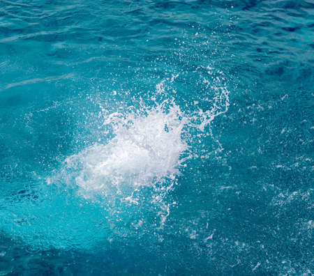 Splashes of blue, sea water with foam bubbles. A splash of nature on a summer day. blue sea background with splashing water. sea vacation concept.の写真素材