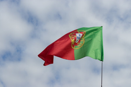 The developing Portuguese flag against the blue sky. Flag close-up in clear weather. space for text.の写真素材