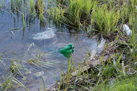 Plastic trash floating in the pond, pollution of the pond, ecology in danger.の写真素材