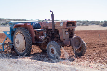 The old rusty tractor stands in the field. rural culture. harvest. agriculture. planting of rural culture.の写真素材