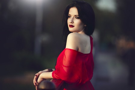 beautiful brunette woman with red lips and dressの写真素材