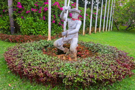 Statue in a flower bed, plants around itの写真素材