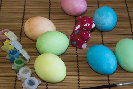 Painted Easter eggs, the painting process, brush, box of paintsの写真素材