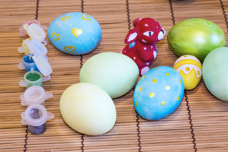 Painted Easter eggs, the painting process, brush, box of paintsの写真素材