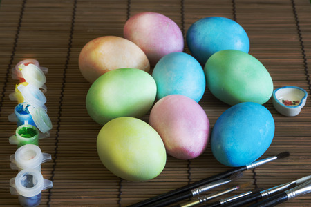 Painted Easter eggs, the painting process, brush, box of paintsの写真素材