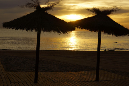 Two thatched umbrella on the beach, Sunrise, golden hourの写真素材