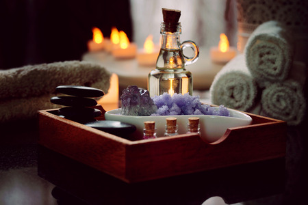 Set for spa procedures from stones for massage, oil, sea salt of violet lies in a wooden box. Moist...