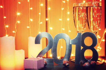 Celebratory card 2018 with champagne, candles and a gift.