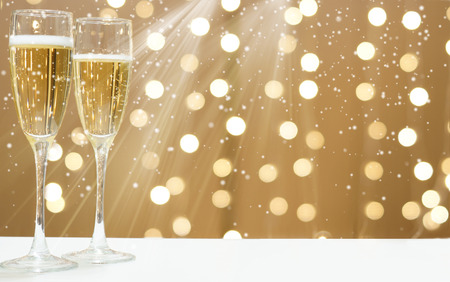 Two glasses of foaming champagne on the background of festive garlands, copy space for your text on the right.の写真素材