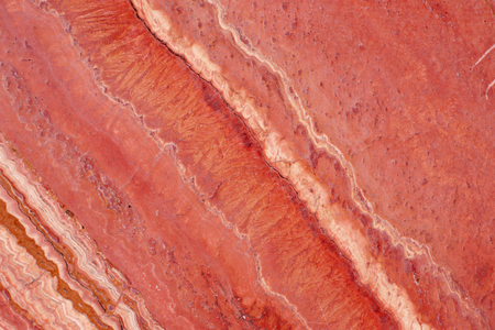 Natural stone of red color, travertine of red color with veins.の写真素材