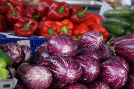 Eggplants and peppers on the vegetable counter on the market.の写真素材