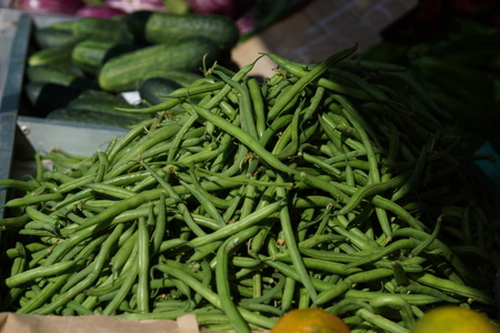 Green string beans lie on the counter in the market.