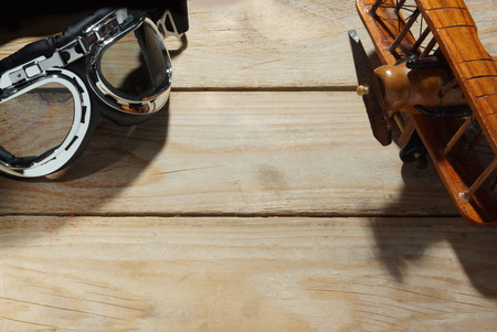 Toy retro airplane and pilots glasses on a wooden tableの写真素材
