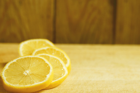 Lemon slices lie on a wooden tableの写真素材
