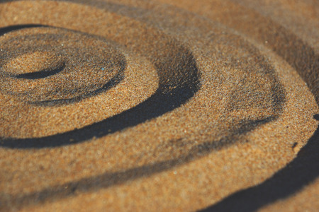 Circles drawn by a finger on the sand.の写真素材