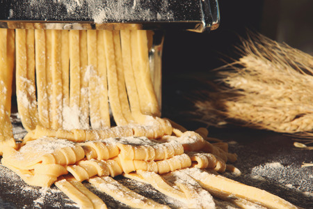 The machine for pasta and homemade tagliatelle, sprinkled with flourの写真素材