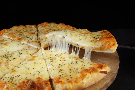 Cheese pizza with crispy crust, the piece is separated from the dish, the cheese stretches and looks...