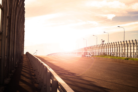 Automobile bridge, sunlit asphalt without cars in the early morning.