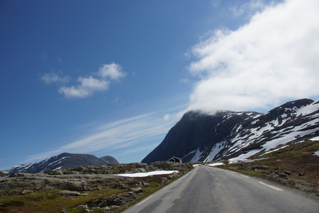 The road goes through a picturesque mountain landscape in Norwayの写真素材