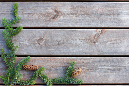 Background for Christmas and New Year from boards with spruce branch with cones.の写真素材