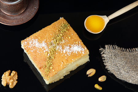 Square honey dessert with nuts on the table.