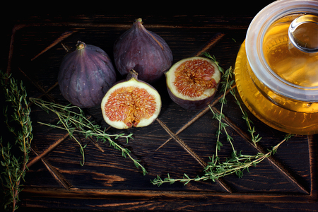 Figs are glued on the board next to a jar of honey and thyme for tea.