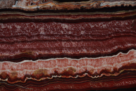Natural red color Onyx stone with dark and light streaks and a beautiful pattern.の写真素材