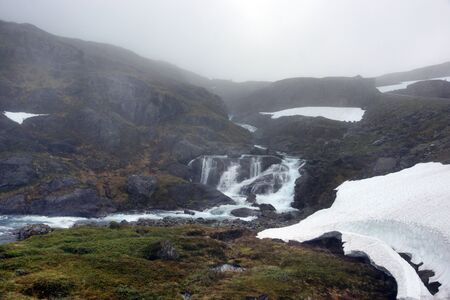 Travel to Norway, the river flows from the mountain, where there is still snow in June.の写真素材