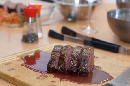 Wooden board with slices of hot beef tenderloin and leaked blood.の写真素材