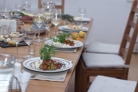 Chairs stand at a beautifully served table with wine, appetizers and caprese salad.の写真素材