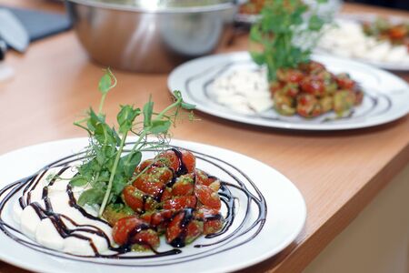 Caprese salad with pesto and herbs for decoration.の写真素材