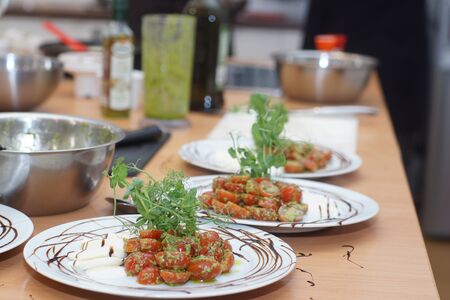 Freshly cooked caprese salad with pesto and cherry tomatoes for a few people.の写真素材