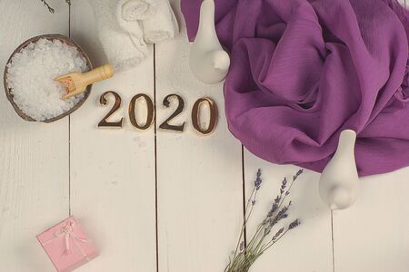 SPA set and golden numbers 2020 on a white plank background with a purple clothの写真素材